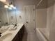 Bright bathroom with double sinks, a large mirror, and a bathtub-shower combination at 502 Willowmere Ct, Cary, NC 27513