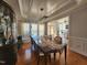 An elegant dining room with beautiful hardwood floors, stylish light fixture, and a large window at 502 Willowmere Ct, Cary, NC 27513