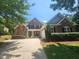 Charming brick home featuring a well-manicured lawn, symmetrical design, and inviting front porch at 502 Willowmere Ct, Cary, NC 27513