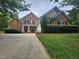 Charming two-story brick home with a well-manicured lawn and inviting front porch at 502 Willowmere Ct, Cary, NC 27513