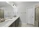 Modern bathroom with double sinks, white countertops, and a glass-enclosed shower at 511 Kenton Mill Ct, Rolesville, NC 27571