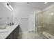 Modern bathroom with double sinks, white countertops, and a glass-enclosed shower at 511 Kenton Mill Ct, Rolesville, NC 27571