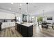 Open-concept kitchen with granite island, stainless appliances, and view into the cozy living room at 511 Kenton Mill Ct, Rolesville, NC 27571