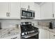 Well-appointed kitchen features stainless steel appliances and white cabinetry at 511 Kenton Mill Ct, Rolesville, NC 27571