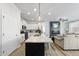Bright, modern kitchen features an island with a granite countertop, seamlessly flowing into the living area at 511 Kenton Mill Ct, Rolesville, NC 27571