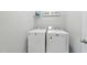 Laundry area with new white washer and dryer, shelving, and modern decor at 511 Kenton Mill Ct, Rolesville, NC 27571