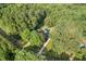 Aerial view of home with a pool surrounded by trees, a winding driveway, and lush greenery at 5414 Ventoria Rd, Durham, NC 27712