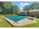 Backyard pool with pool cover, adjacent to screened porch, surrounded by a green lawn and mature trees at 5414 Ventoria Rd, Durham, NC 27712