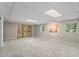 Spacious finished basement with neutral carpet, lighting, and outdoor access at 5414 Ventoria Rd, Durham, NC 27712