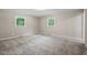 Spacious bedroom featuring neutral walls, plush carpeting, and natural light from two windows at 5414 Ventoria Rd, Durham, NC 27712