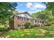 Two-story brick home with manicured lawn and mature trees, offering classic charm and curb appeal at 5414 Ventoria Rd, Durham, NC 27712