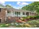Charming brick home with a covered front porch, landscaped yard, and stepping stones pathway at 5414 Ventoria Rd, Durham, NC 27712