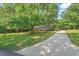 Charming home with manicured front yard, mature trees, and a long, paved driveway at 5414 Ventoria Rd, Durham, NC 27712