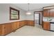 Charming kitchen area featuring wooden paneling, a window, and an adjacent laundry area at 5414 Ventoria Rd, Durham, NC 27712
