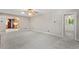Open living area with neutral carpet, lighting, and view to kitchen area and exterior door at 5414 Ventoria Rd, Durham, NC 27712