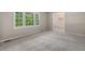 Bright living room with large windows, neutral carpet, and seamless flow into adjacent rooms at 5414 Ventoria Rd, Durham, NC 27712