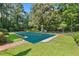 View of backyard pool with cover, surrounded by lush greenery and mature trees at 5414 Ventoria Rd, Durham, NC 27712