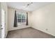 A bedroom with a large window and neutral colored carpet and walls at 5503 Silver Moon Ln, Raleigh, NC 27606