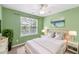 A tastefully decorated bedroom with green walls, a white bed, and an abstract painting above the bed at 5503 Silver Moon Ln, Raleigh, NC 27606