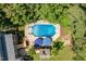 Aerial view of a private backyard oasis, including a pool with umbrellas and a cabana at 5712 Turner Store Ln, Raleigh, NC 27603