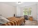 Neutral bedroom with a comfortable single bed, natural light, and desk with chair at 5712 Turner Store Ln, Raleigh, NC 27603