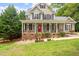 Lovely home with a welcoming front porch, vibrant landscaping, and a striking red front door at 5712 Turner Store Ln, Raleigh, NC 27603