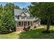 Beautiful two-story home with a red front door, complemented by a covered porch and lush greenery at 5712 Turner Store Ln, Raleigh, NC 27603