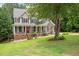 Charming two-story home with a covered front porch, a bright red door, and meticulous landscaping at 5712 Turner Store Ln, Raleigh, NC 27603