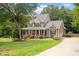 Inviting two-story home with a classic porch, well-manicured lawn, and a welcoming driveway at 5712 Turner Store Ln, Raleigh, NC 27603