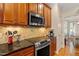 Kitchen features stainless appliances, granite countertops, backsplash, and cherry cabinets at 5712 Turner Store Ln, Raleigh, NC 27603