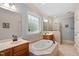 Inviting main bathroom featuring dual sinks, a soaking tub, and separate shower area at 5712 Turner Store Ln, Raleigh, NC 27603