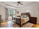 Well-lit main bedroom with a tray ceiling, ceiling fan and a view overlooking the backyard at 5712 Turner Store Ln, Raleigh, NC 27603