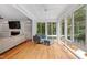 Bright sunroom featuring floor to ceiling windows, with hardwood floors, and fireplace at 5712 Turner Store Ln, Raleigh, NC 27603