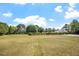Well-maintained yard with green grass, lush trees, and blue sky and clouds, creating a serene and beautiful outdoor space at 5712 Turner Store Ln, Raleigh, NC 27603