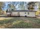 Side view of a single-story home with a wooden deck in a spacious, partially shaded backyard at 5917 Meadowlark Ln, Raleigh, NC 27610
