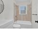 Bathroom with white tiled walls, vanity, toilet and bathtub and bright window at 631 Park Ave, Rocky Mount, NC 27801