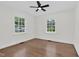 A bedroom with hardwood floors, ceiling fan, and two bright windows at 631 Park Ave, Rocky Mount, NC 27801