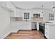 Renovated kitchen features stainless appliances and white cabinets and brick backsplash at 631 Park Ave, Rocky Mount, NC 27801