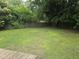 Large backyard with mature trees and green lawn, providing privacy and plenty of space for outdoor activities at 704 N King Charles Rd, Raleigh, NC 27610