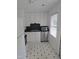 Efficient kitchen features white cabinets, stainless steel appliances, and black and white tile flooring at 704 N King Charles Rd, Raleigh, NC 27610