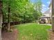 Large backyard with a meticulously maintained lawn, mature trees, and a pergola at 7906 Longleaf Branch Ct, Raleigh, NC 27612
