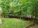Backyard featuring a manicured lawn, trampoline and wood perimeter fence and trees at 7906 Longleaf Branch Ct, Raleigh, NC 27612