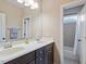 Bathroom featuring double sinks with dark cabinets and a shower with a shower curtain at 7906 Longleaf Branch Ct, Raleigh, NC 27612