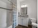 Bathroom featuring a tub with tiled walls, white cabinets, and a mirrored vanity at 7906 Longleaf Branch Ct, Raleigh, NC 27612