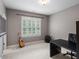 Bedroom with carpet flooring, a window with white blinds, a guitar, and a dark desk at 7906 Longleaf Branch Ct, Raleigh, NC 27612