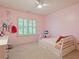This bedroom features pink walls, white trim, a ceiling fan, and carpeted floors at 7906 Longleaf Branch Ct, Raleigh, NC 27612