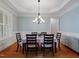 Formal dining room boasts wainscoting, light blue walls, hardwood floors and a decorative light fixture at 7906 Longleaf Branch Ct, Raleigh, NC 27612