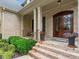 Covered front porch with brick steps, brick facade, and a wood door at 7906 Longleaf Branch Ct, Raleigh, NC 27612