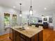 Open kitchen featuring granite countertops, a center island, and stainless steel sink with wood floors at 7906 Longleaf Branch Ct, Raleigh, NC 27612