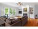 Living room with hardwood floors, fireplace, built-in shelving, and large windows at 7906 Longleaf Branch Ct, Raleigh, NC 27612